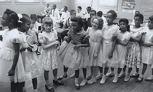 One of the first schools to implement desegregation is Barnard Elementary in Washington, DC. This photo shows black and white children in the same classroom.
