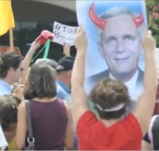 Anti-reform protesters carry signs depicting Doggett with ‘devil horns’ and a sign featuring Nazi SS lettering.