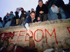 West and East Germans come together as the Berlin Wall is torn down.