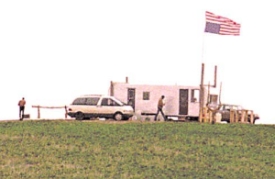 Two armed Freemen man a patrol outpost on their besieged ranch. The US flag is flown upside down to indicate distress.