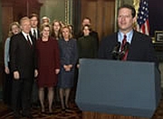 Al Gore giving his concession speech. His running mate, Joe Lieberman, and Gore and Lieberman family members look on.