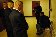 Several of Joe Miller’s private security guards stand over a handcuffed Tony Hopfinger, whom they detained during a political event.