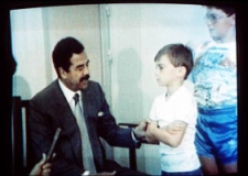 Saddam Hussein inquires about the health of young British hostage Stuart Lockwood, a scene broadcast on Iraqi television and shown worldwide.