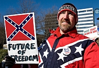A League of the South member at a 2008 political rally. This member is wearing a button supporting the candidacy of Ron Paul (R-TX). The sign behind the supporter calls the NAACP a “racist” organization.