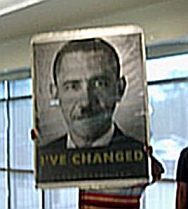 An anti-reform protester displays a large sign depicting President Obama as Adolf Hitler.