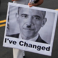 An anti-health care reform protester carries a poster depicting President Obama as Adolf Hitler.