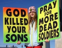 Signs held by a WBC picketer at the funeral of a fallen soldier.