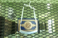 A Koran kept for detainees’ use at Guantanamo. The surgical mask is provided to keep the Koran off the floor, and the guards from touching the book.