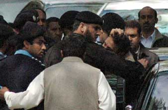 Iftikhar Chaudhry being arrested by secret agents. An agent is holding Chaudhry’s hair as he is being pushed into a car. 